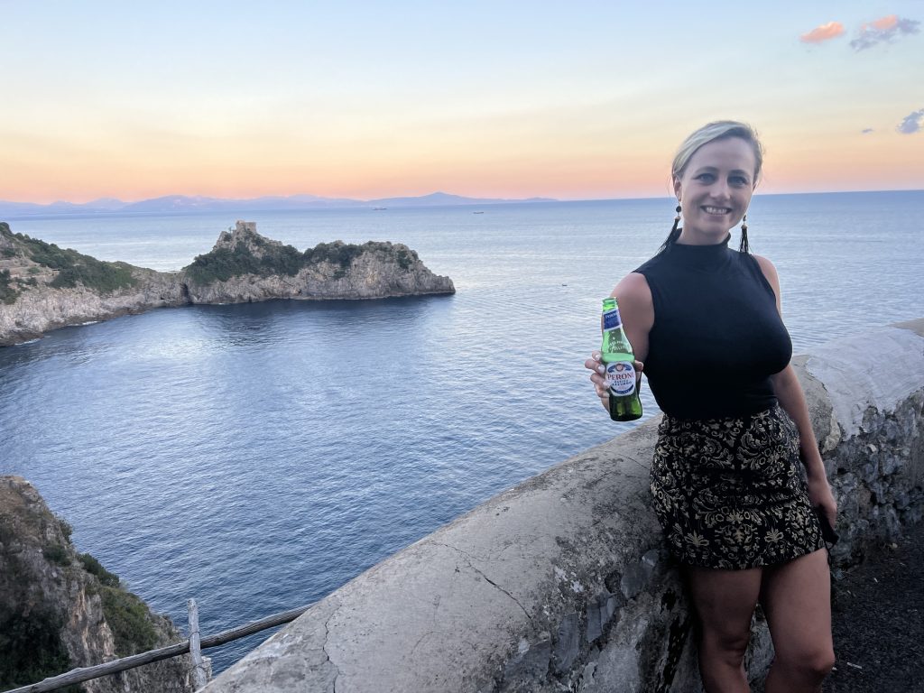 holding a beer overlooking the amalfi coast
